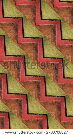 Seamless zigzag pattern created from aerial landscape textures, combining red pathways, green grass, and earthy soil tones. Bold geometric repeat ideal for backgrounds and design use