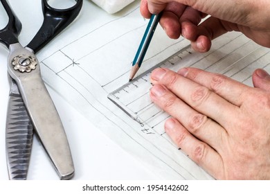 Seamstress is drawing pattern for face mask. Woman prepares to sew protection accessorize from viruses. Healthcare concept - Shutterstock ID 1954142602
