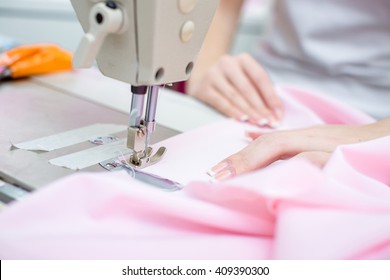 seamstress sewing on sewing machine clothes. sewing workshop. hand and sewing machine closeup