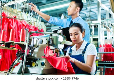 Seamstress Or Worker In A Factory Sewing With A Sewing Machine, A Foreman Checks The Yarn