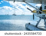 Seaplane floating in the water at Dry Tortugas National Park with distant boats. 