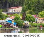 Seaplane at a harbor dock by houses in a residential area of the city of Wrangell late in the afternoon early in summer in southeastern Alaska, for motifs of lifestyle, travel, and connections