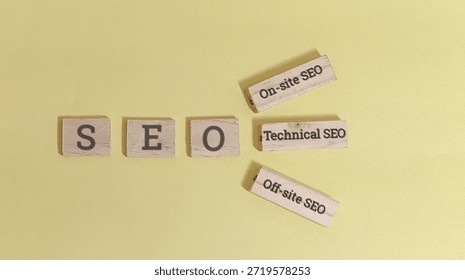 Search engine optimization blocks spell out seo while related concepts like technical on site and off site marketing methods are scattered nearby against a simple light yellow background illustrating internet ranking factors.