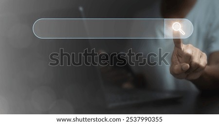 Search Engine Optimization concept. Businessman using laptop and touching search bar  on virtual screen.