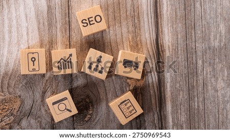 Search engine optimization concept with wooden blocks showing SEO text and digital marketing icons such as analytics, search, mobile, network and logistics on wooden background representing online marketing strategy.