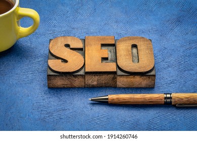search engine optimization (SEO) - acronym in vintage letterpress wood type printing with a pen and coffee, internet and web design concept