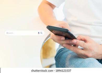 Search Engine Optimization - SEO concept. Closeup of a male's hands using a smartphone with search bar graphic beside. Machine learning, AI Artificial intelligence, Smart search, Keyword research.