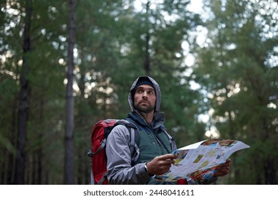 Search, forest and man with map for direction to camp in woods and thinking of adventure navigation. Confused, travel and lost in nature trekking with backpack and plan to location on hiking journey - Powered by Shutterstock