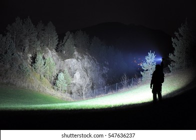 Search Light Shining On A Hill Side With Trees And Small Quarry