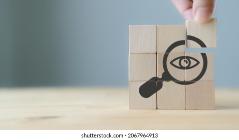 Search, Research, Finding Solution, Investigate Concept. Hand holds the wooden cubes with magnifying glass with eye symbols on grey background, copy space. Marketing research. Customer insight. SEO. - Powered by Shutterstock - Get 15% off with code: PIKWIZARD15