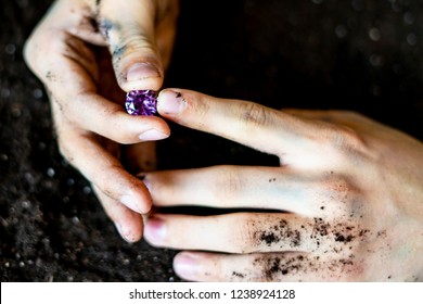 Searcher Hands Holding A Diamond In The Soil Ground