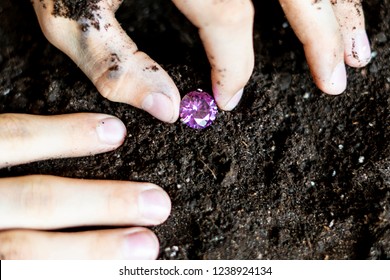 Searcher Hands Holding A Diamond In The Soil Ground