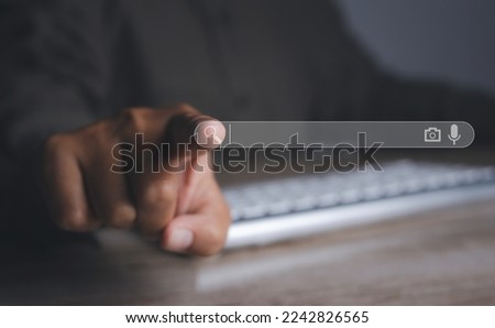 Searching browsing internet data information networking concept. Search Engine Optimization SEO Networking. Man hand presses the information search button on search bar virtual screen, copy space.