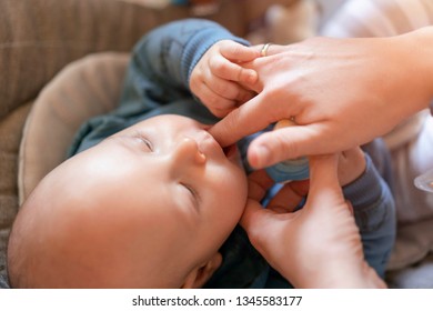 Searching For The First Babies Tooth. Mother Tries To Sooth Teething Pain. Close Up, Selective Focus.