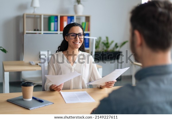 Searching\
for job concept. Happy human resources manager speaking to\
employment applicant on work interview, holding CV at office.\
Personnel manager talking to vacancy\
candidate