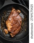 Seared beef chuck eye roll steak in skillet with rosemary and butter. Gourmet beef dish with rich flavor and copy space