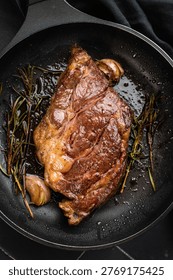 Seared beef chuck eye roll steak in skillet with rosemary and butter. Gourmet beef dish with rich flavor and copy space