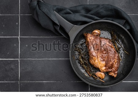 Seared beef chuck eye roll steak in skillet with rosemary and butter. Gourmet beef dish with rich flavor and copy space
