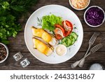 Seared halibut and fresh vegetables on wooden table 