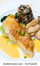 Seared Sea Bass With Orange Miso Sauce, Wild Rice And Seasonal Vegetable, Close Up