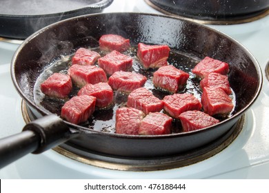 Searing Beef Bottom Round Roast Cubes In Cast Iron Skillet , Meat Just Added To Hot Oil , The Upper Sides Are Still Red