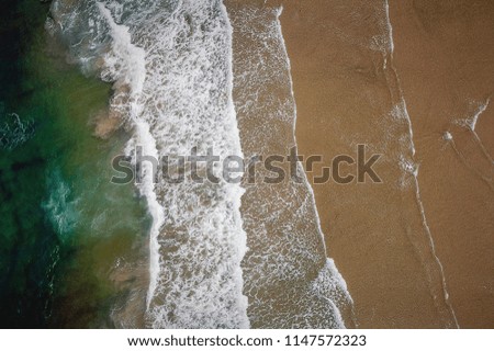 Similar – Luftaufnahme Panoramadrohne Blick auf den blauen Ozean Wellen, die am Sandstrand in Portugal erdrücken.