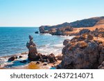 Seascape. Bizarre rocks on the seashore on a sunny summer day. General beaches of the Azov Sea.