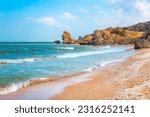 Seascape. Blue sea and rocky shore with yellow sandy beach. Sea of Azov in Crimea.