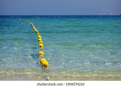 Seascape With Floating Buoys And Rope Dividing Area On Beach. Clear Blue Water And Sandy Beach On Sea Shore Of Al Mamzar Beach Dubai. Selective Focus, Blurred Background