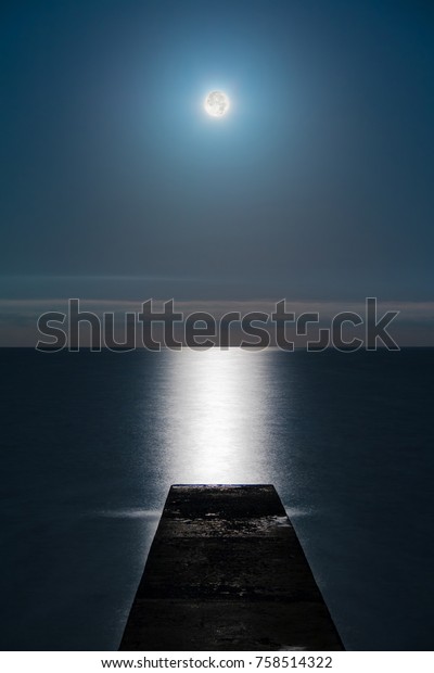Seascape with the full moon over the sea and the\
mole in line with the moon\
glade