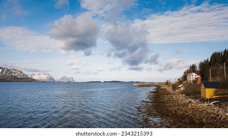 seascape inside the Island of Senja in the area of Skaland with snowcapped mountain in the background, Norway - Powered by Shutterstock