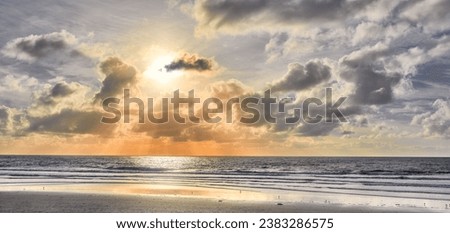 Seascape and landscape of a golden sunset on the west coast of Jutland in Loekken, Denmark. Beautiful cloudscape on an empty beach at dusk. Clouds over the ocean and sea in the morning with copyspace