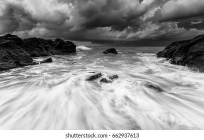 seascape rock beach,in black and white during storms , A slow shutter speed was used to see the movement ( Soft focus due to long exposure shot ) - Powered by Shutterstock