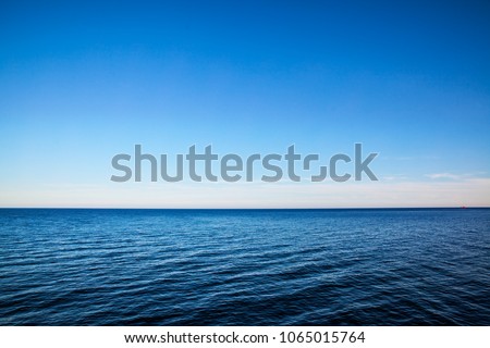 Seascape with sea horizon and almost clear deep blue sky - Background