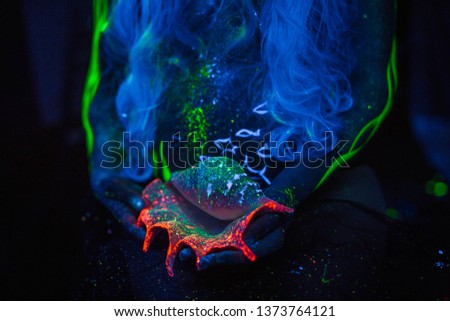 seashell in the neon light in the hands of a pregnant girl