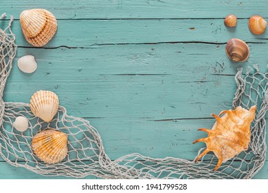 Seashells and fishing net on turquoise wooden background