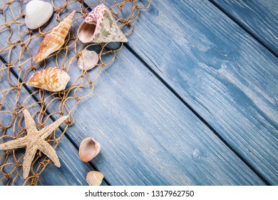 Seashells and starfishes on blue wooden background.