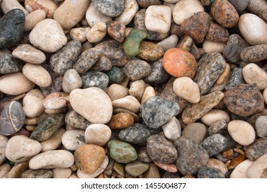 Seashore with gravel stone in summer, close up view. Texture of jackstone. Multicolour pebbles, abstract background