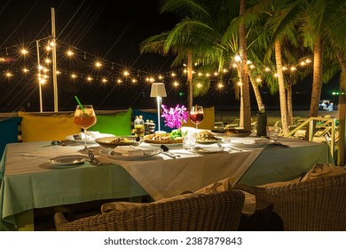 Seaside dinner table,Romantic dinner setting on the beach at sunset ,Romantic dinner setting on the beach at sunset