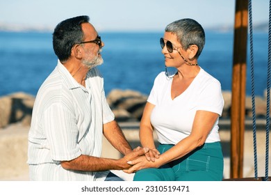 Seaside Holidays. Loving Retired Couple Holding Hands Sitting On Swings Outside, Having Date By The Sea, Creating Lasting Travel Memories. Summer Vacation And Tourism Concept - Shutterstock ID 2310519471