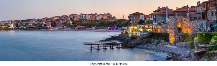 Seaside landscape, panorama, banner - view of the embankment with fortress wall during sunset in the city of Sozopol on the Black Sea coast in Bulgaria