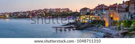 Seaside landscape, panorama, banner - view of the embankment with fortress wall during sunset in the city of Sozopol on the Black Sea coast in Bulgaria
