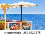 Seaside landscape - view of the cafe on the embankment against the background of the sea, in the Old Town of Nesebar, on the Black Sea coast of Bulgaria