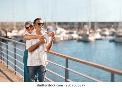 Seaside Love. Senior Married Couple Embracing Posing At Marina Dock With Sailboats, Looking Aside At Free Space, Advertising Yacht Cruise, Enjoying Sunny Day By The Sea Outside - Powered by Shutterstock