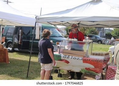 SEASIDE PARK, NEW JERSEY/U.S.A. – AUGUST 14 2020: A Person Shops At An Open Air Farmers Market. The Food Vendor Wears Protective Shield And Flu Mask.
