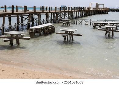 Seaside pier and tables on a sunny day at the beach - Powered by Shutterstock