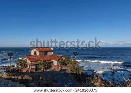 seaside view with a beautiful house on the cliff and horizon over the blue sea