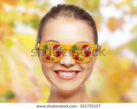 season and people concept - happy face of teenage girl in sunglasses with autumn leaves reflection over natural background