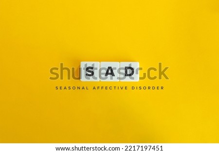Seasonal affective disorder (SAD) banner. Winter Depression. Block Letter Tiles on Yellow Background. Minimal Aesthetics.
