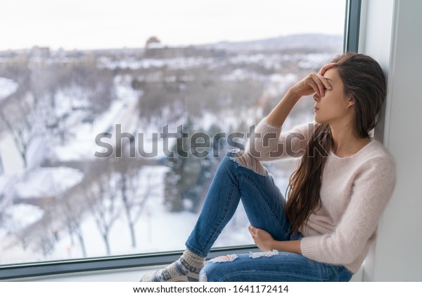 Seasonal affective disorder SAD\
depression winter season anxious alone young girl feeling lonely -\
stress, anxiety, melancholy emotion at home. Mental health\
problem.